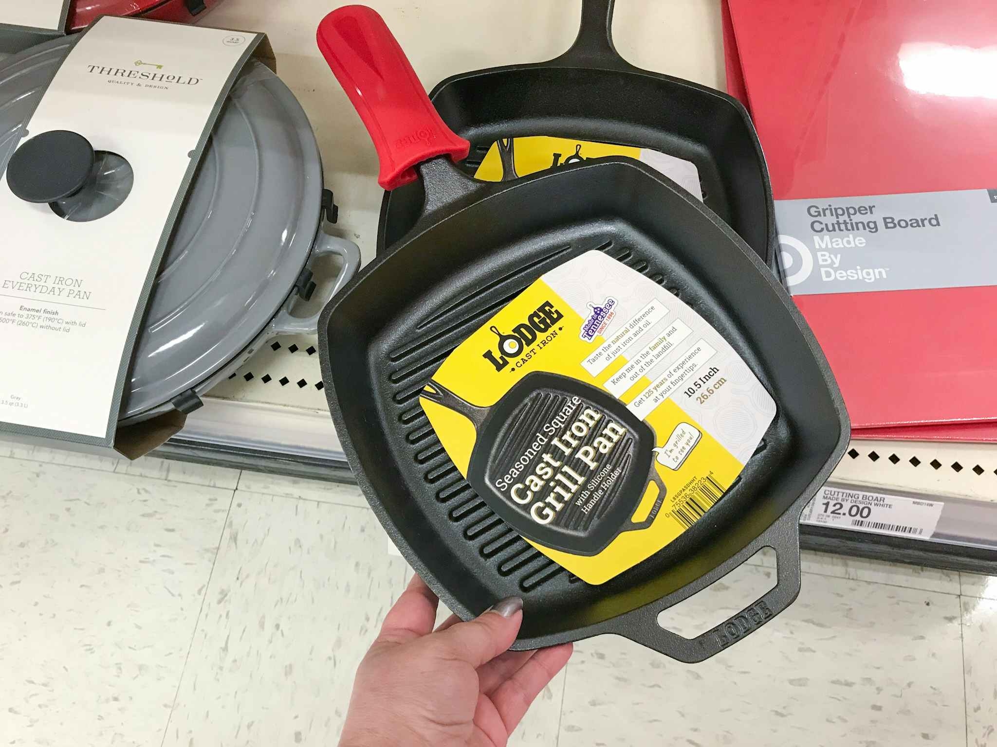 hand grabbing a lodge cast iron grill pan off a target shelf