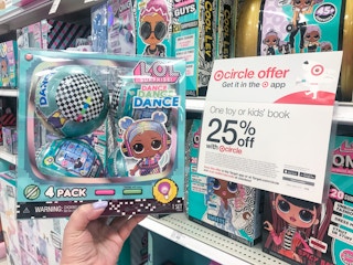 hand holding a 4-pack of lol surprise dance dance dance dolls at target