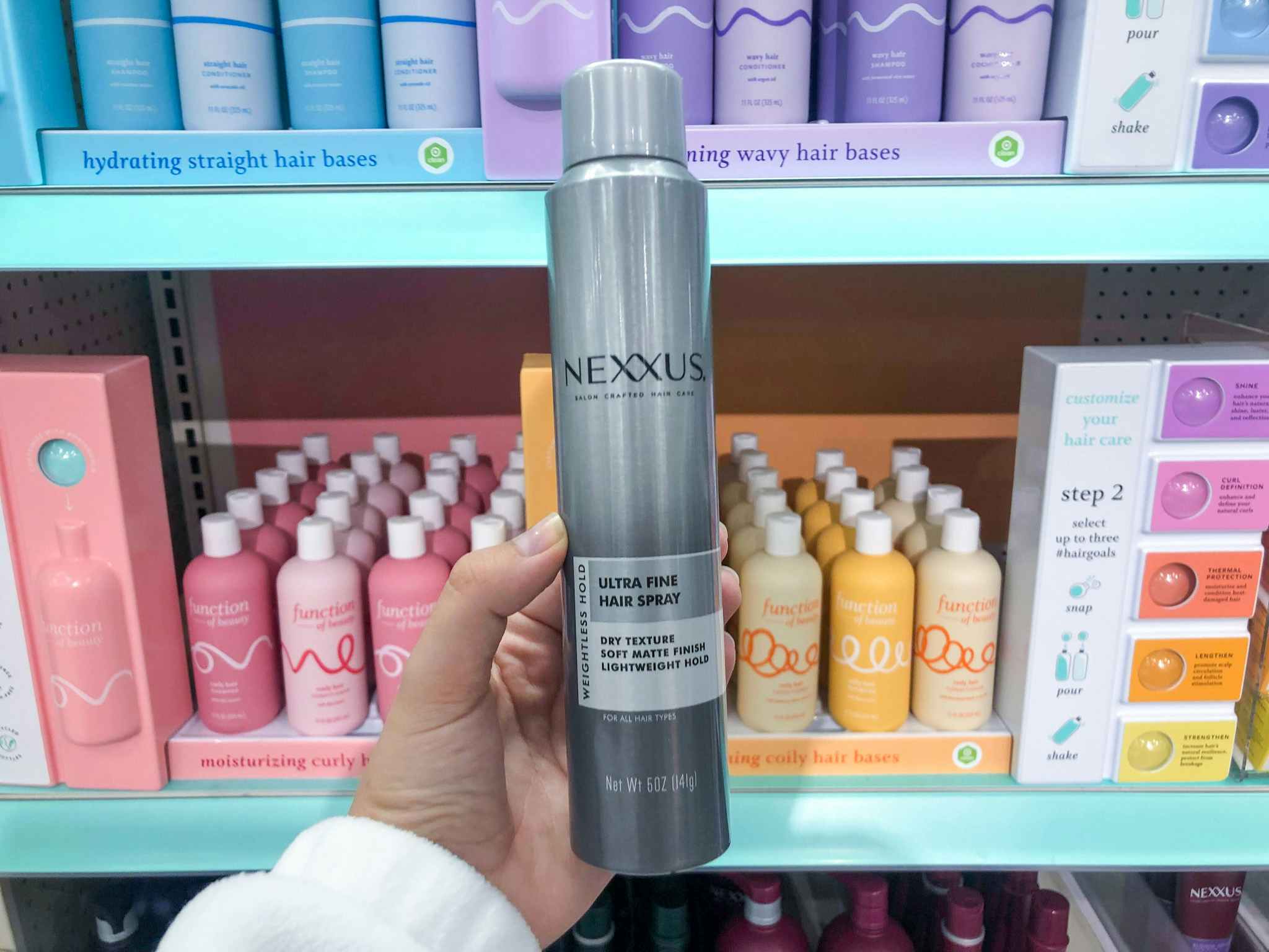 hand holding nexxus hairspray at target