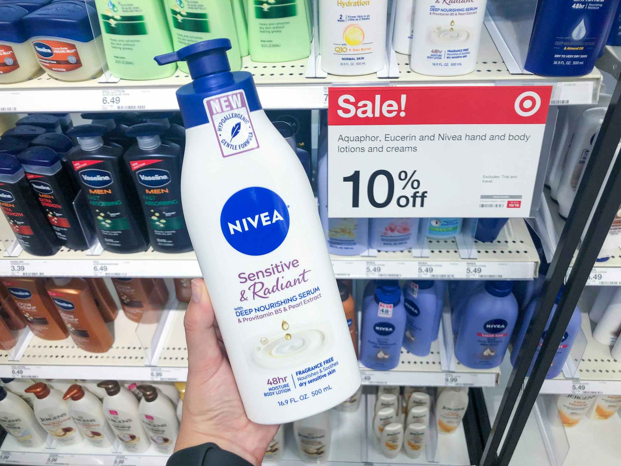 hand holding a bottle of nivea sensitive and radiant lotion in front of target sale sign