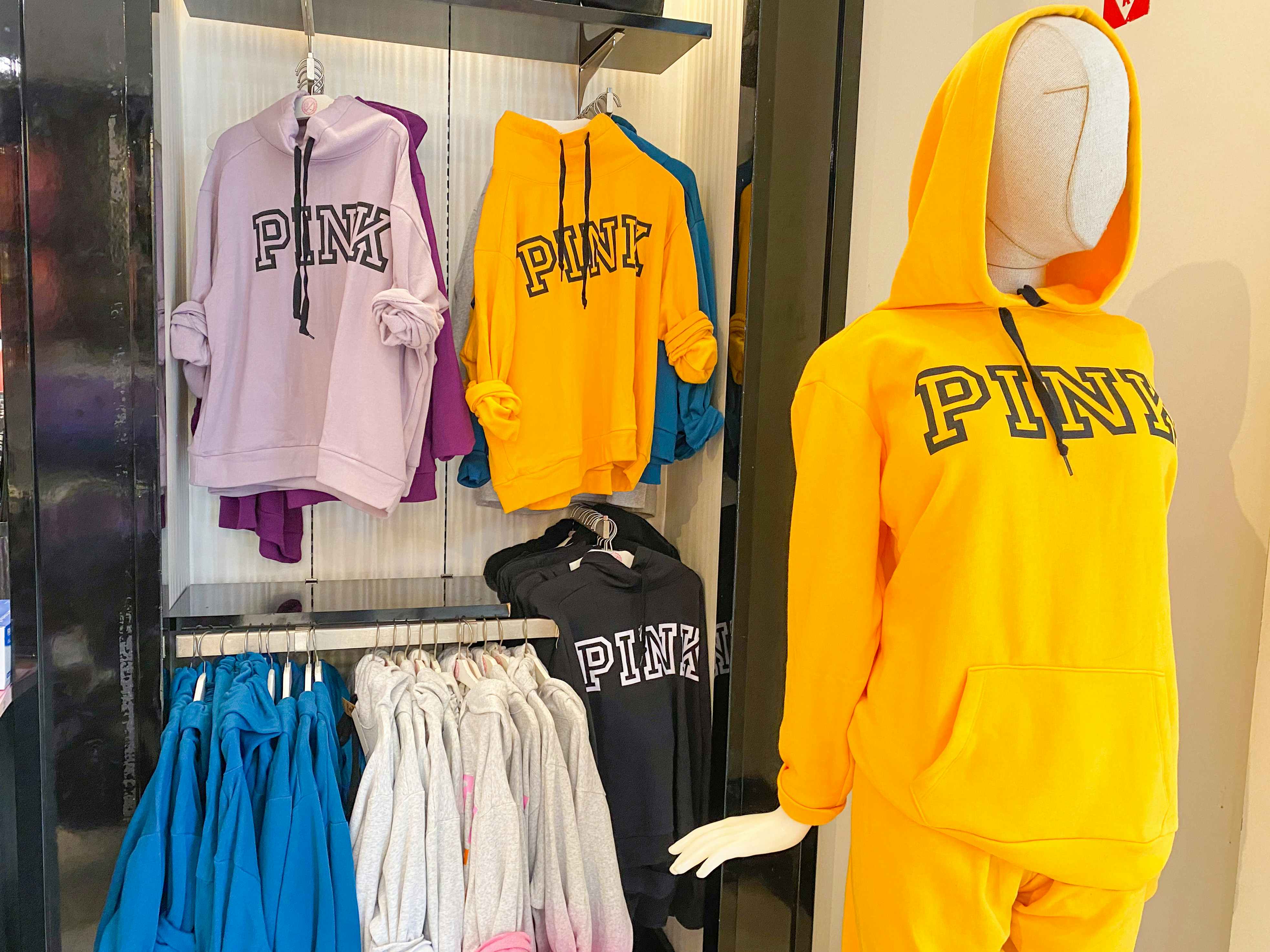 Some PINK brand hoodies on display in a PINK store.