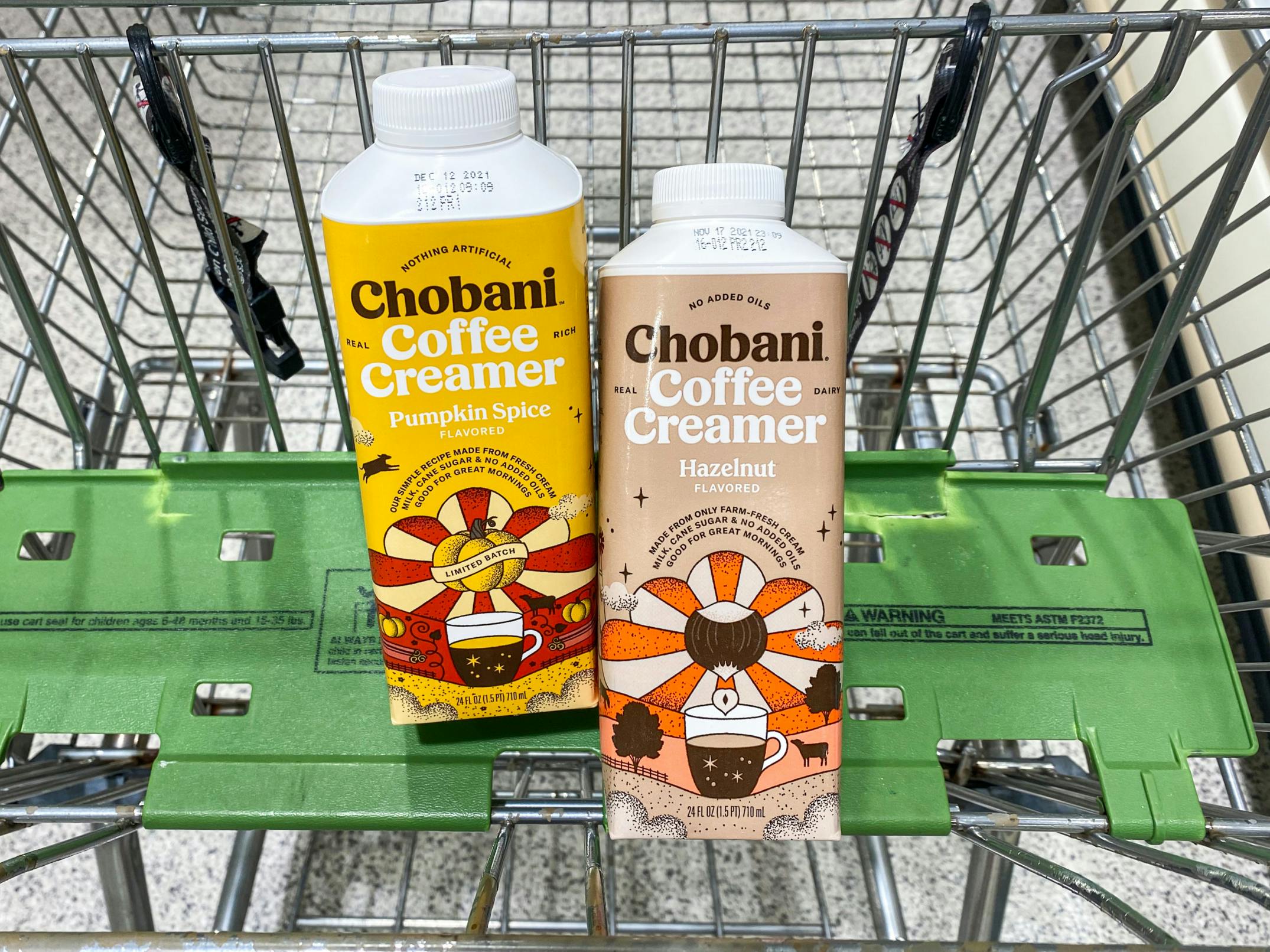 Two bottles of Chobani coffee creamer in a grocery cart