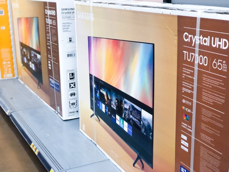 Samsung 65-inch TVs stocked on a shelf at Walmart.