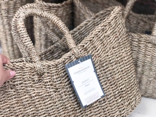 hand grabbing a studio mcgee braided basket at target