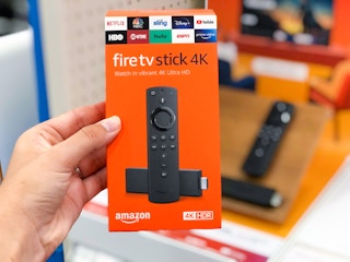 person holding amazon firetv stick 4k box