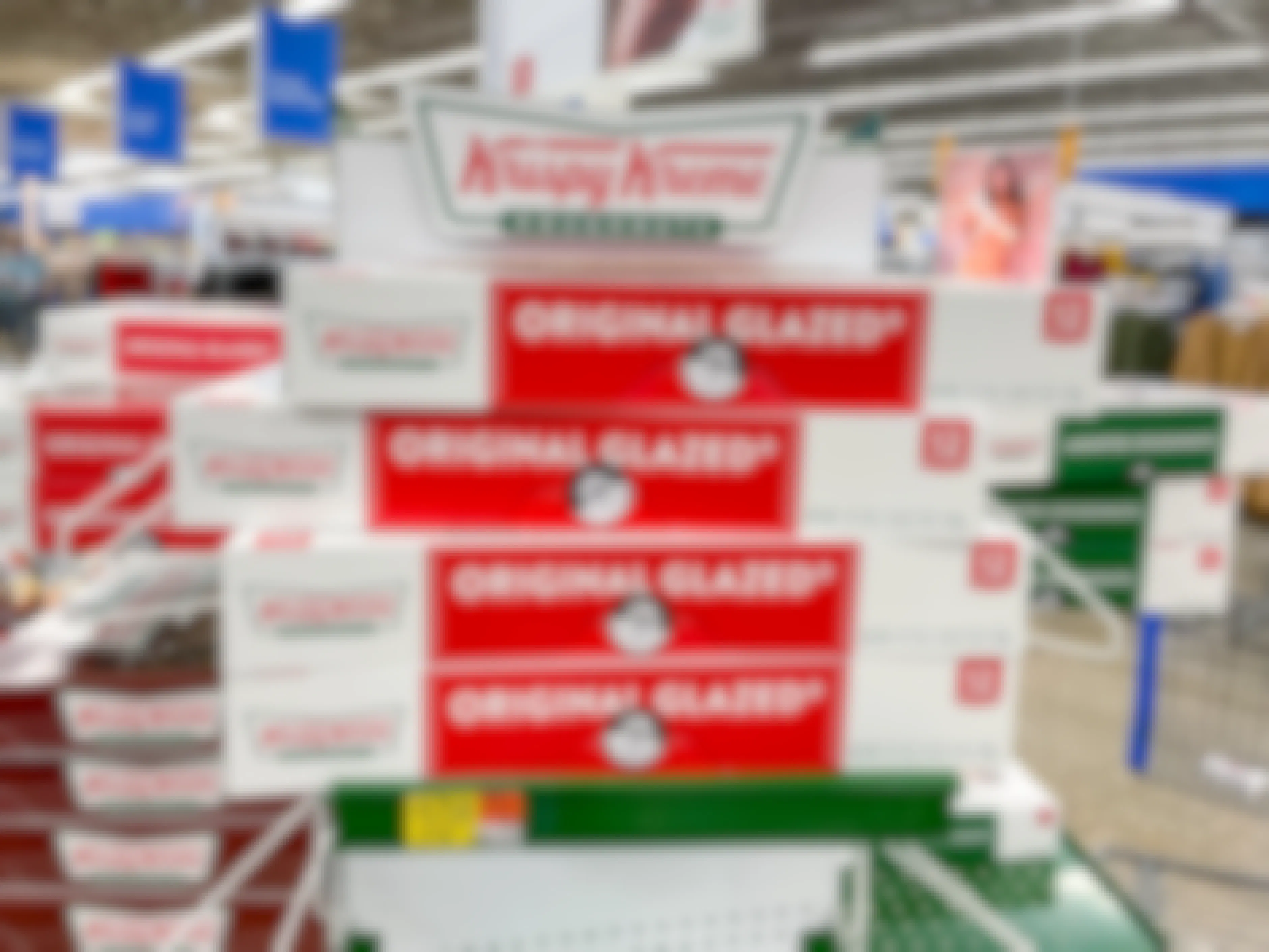 A stack of boxed dozens of Krispy Kreme original glazed doughnuts on a shelf at Walmart.