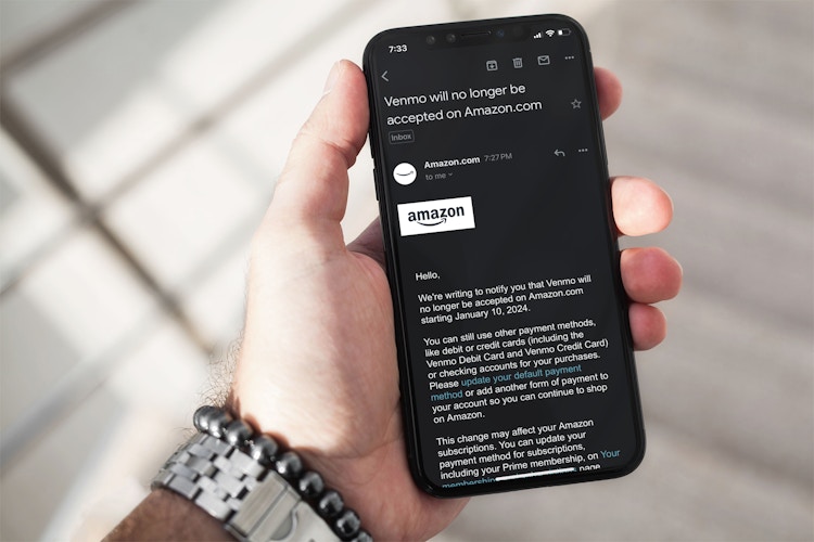 someone holding a phone showing an email from Amazon