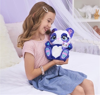 A girl playing with a Peek-A-Roo panda toy.
