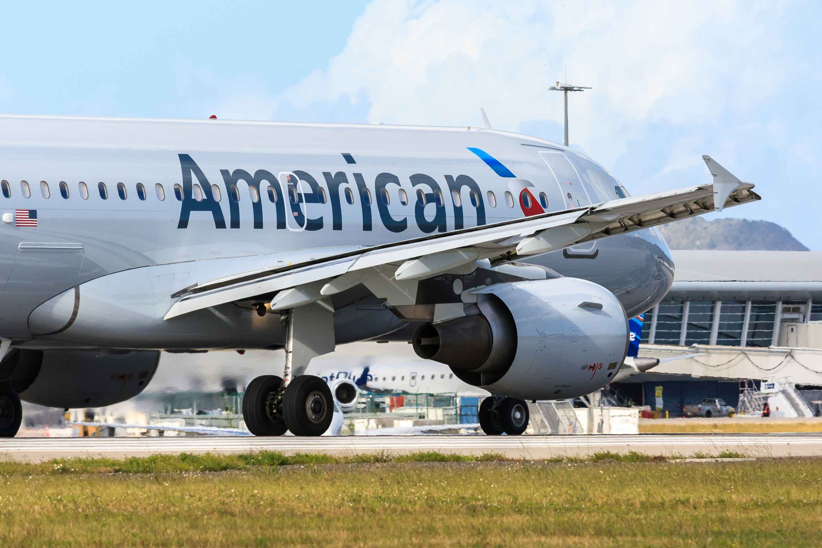 An American Airlines plane on the runway outside of an airport.