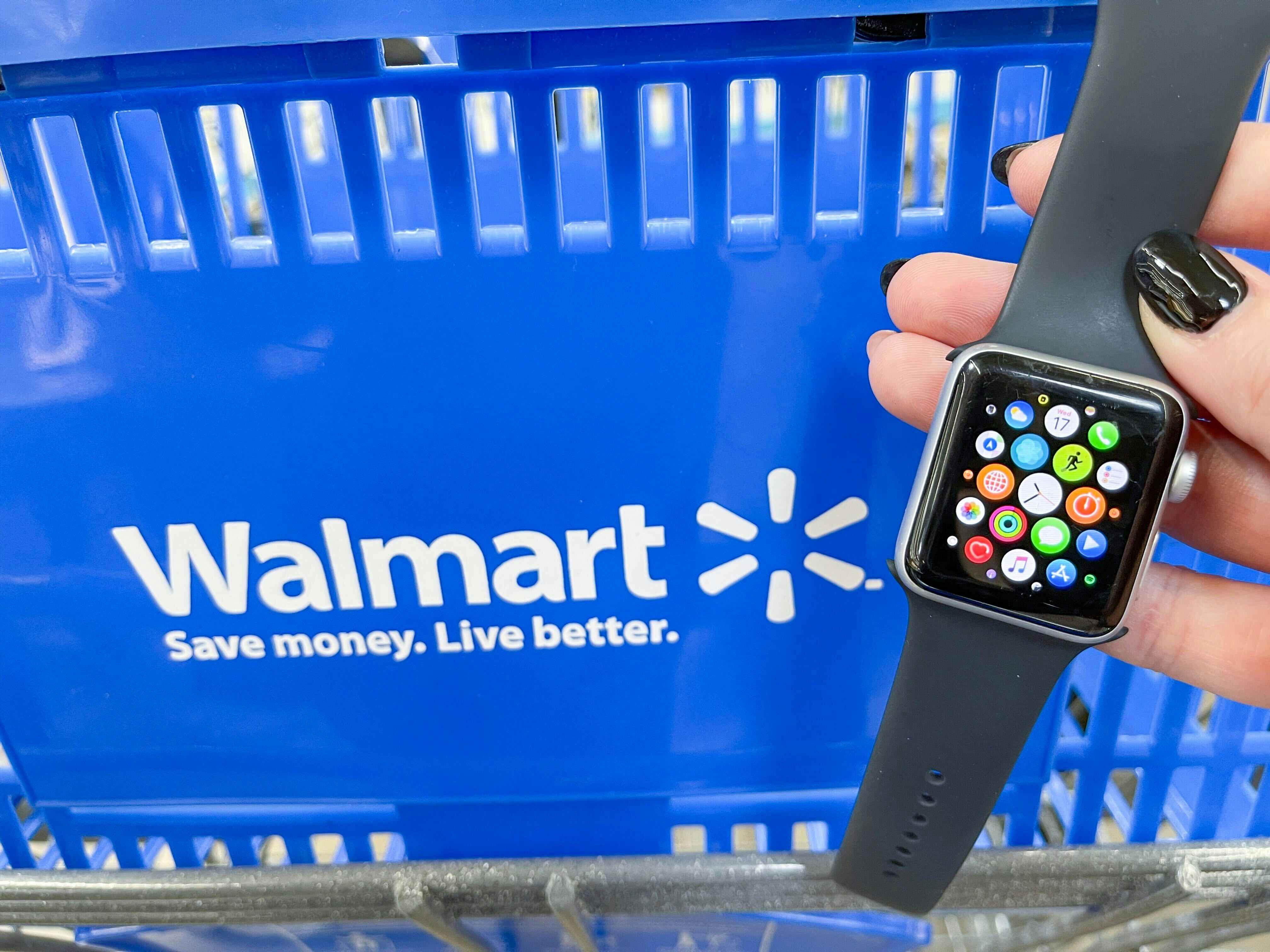 someone holding up an apple watch infront of a Walmart shopping basket