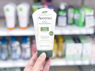 hand holding aveeno face cream at target