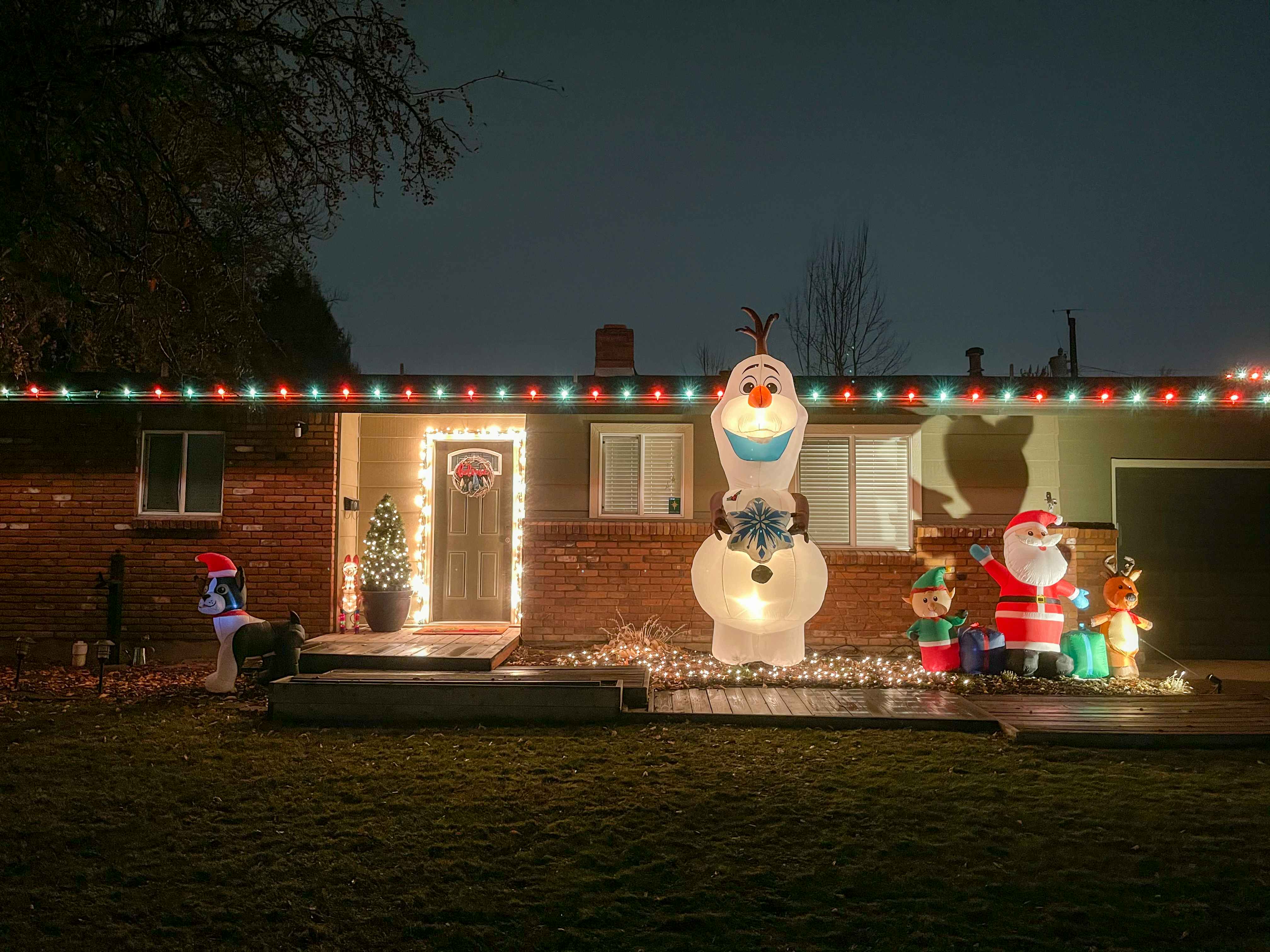 A house with Christmas lights and inflatables out front