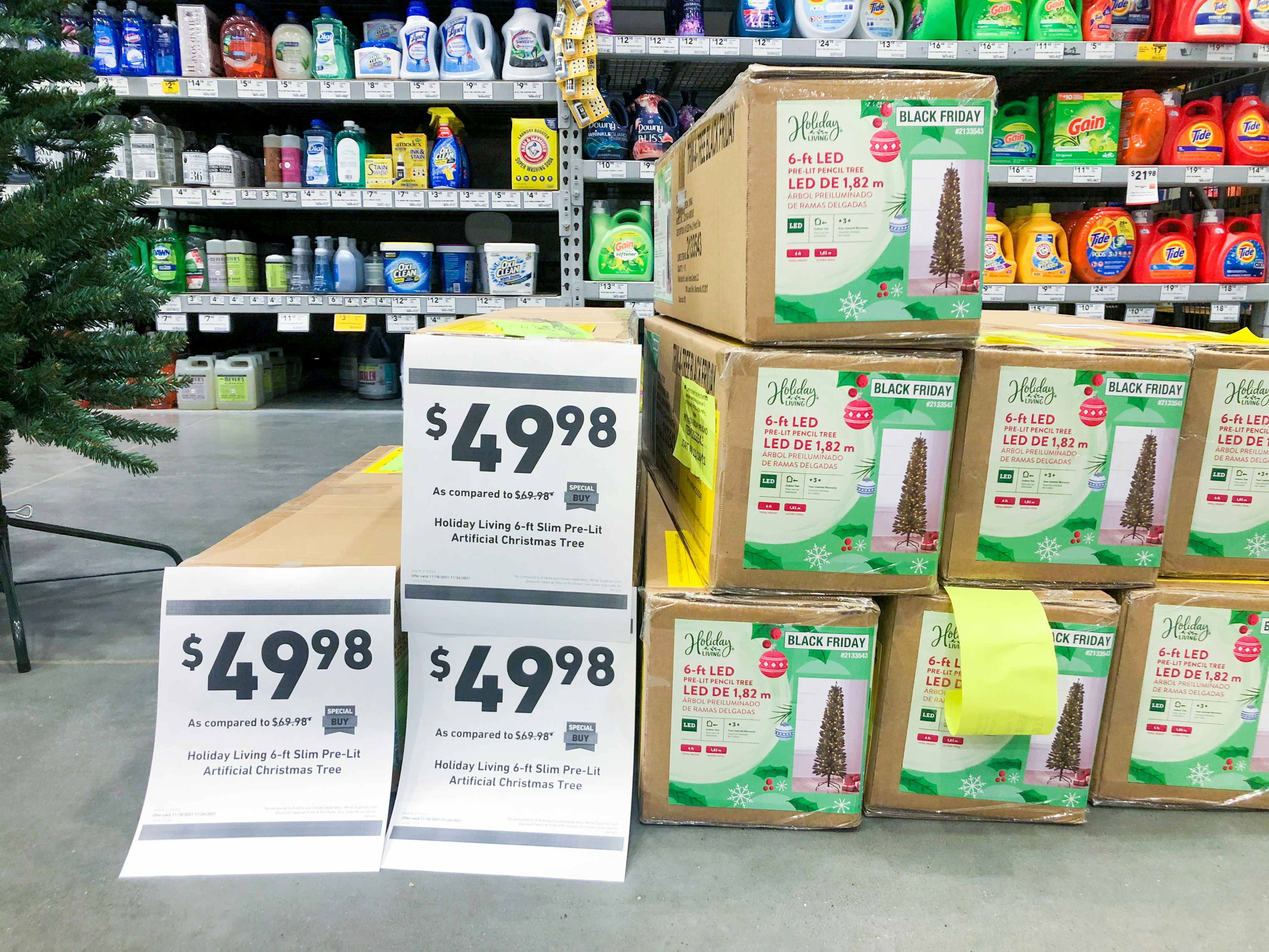 Boxed Christmas trees on display at Lowe's with signs advertising their price to be $49.98