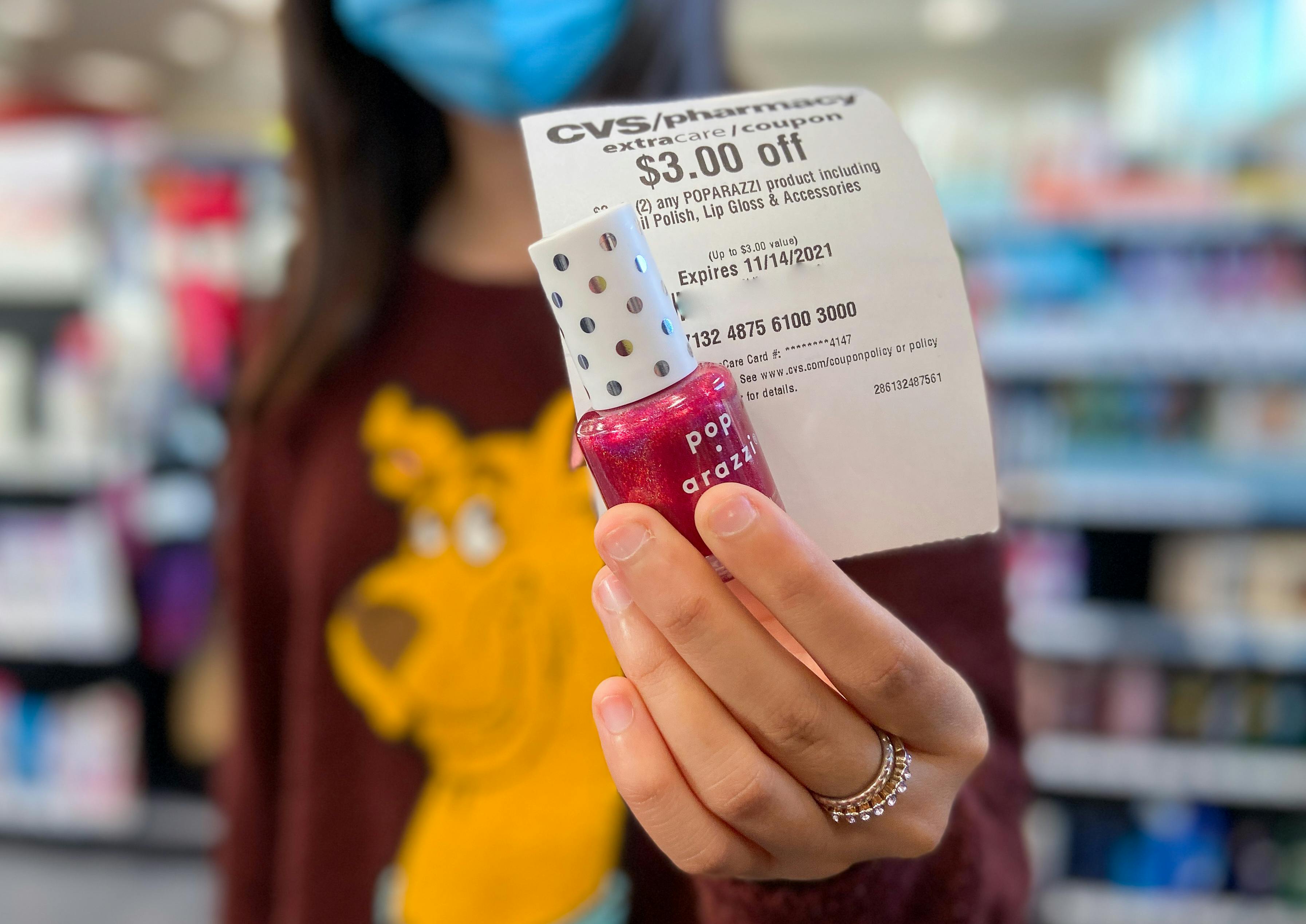 someone holding nail polish and cvs coupon