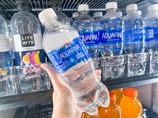 someone holding aquafina bottle