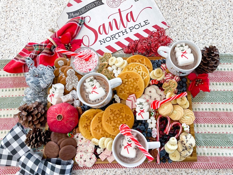 holiday charcuterie board with hot coco, cookies, and waffles