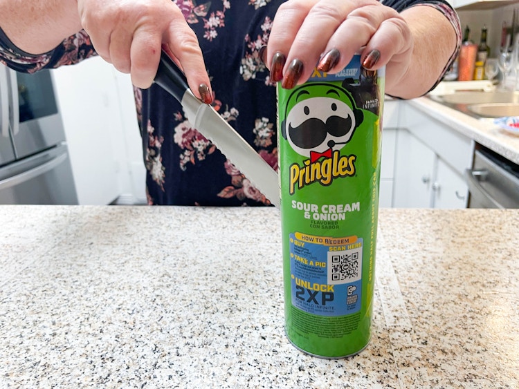 woman cutting pringles can in half 