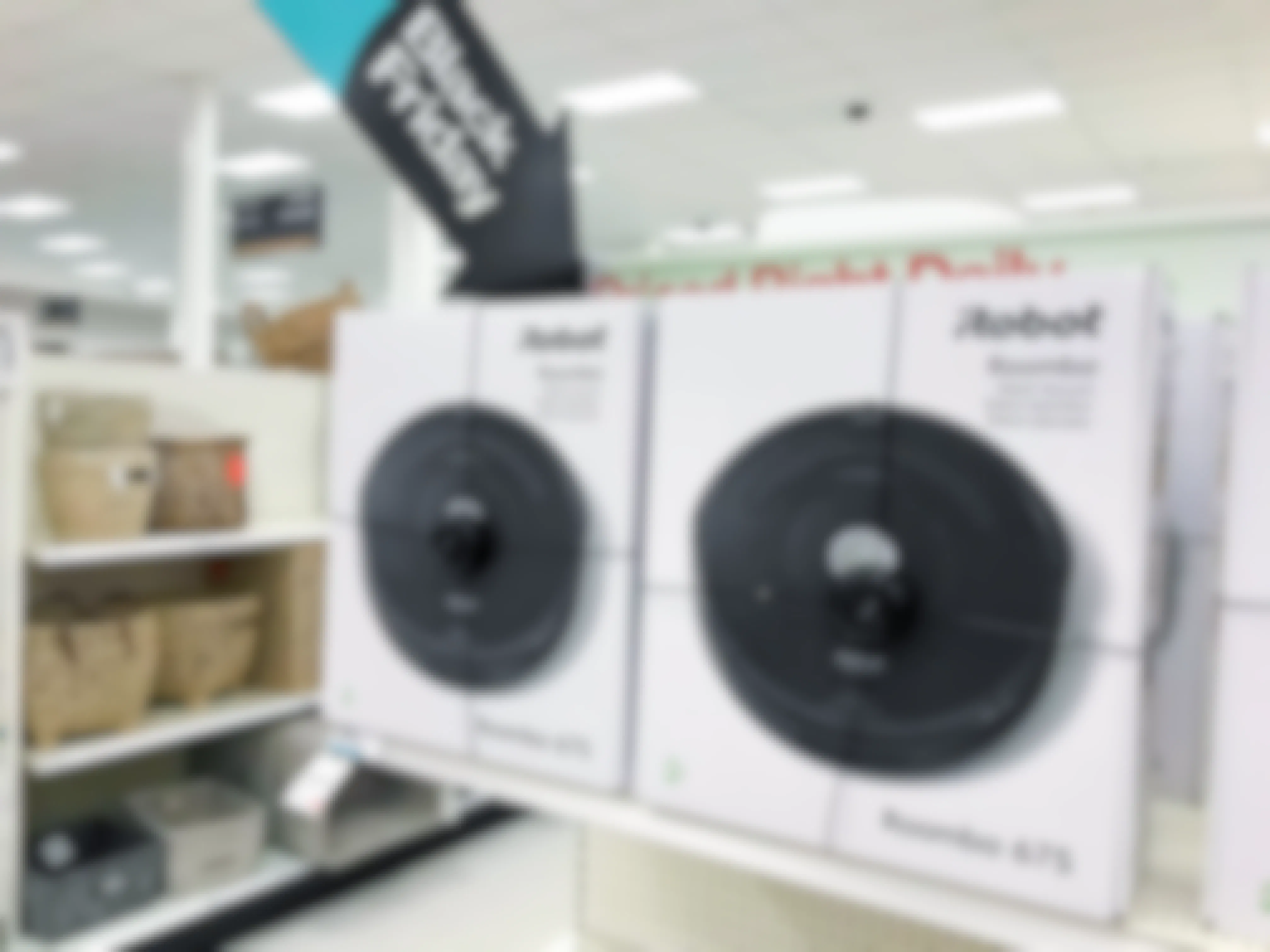 Amazon iRobot Roombas on a shelf with a big sign shaped like an arrow that says, "Black Friday" pointing to the Roombas.
