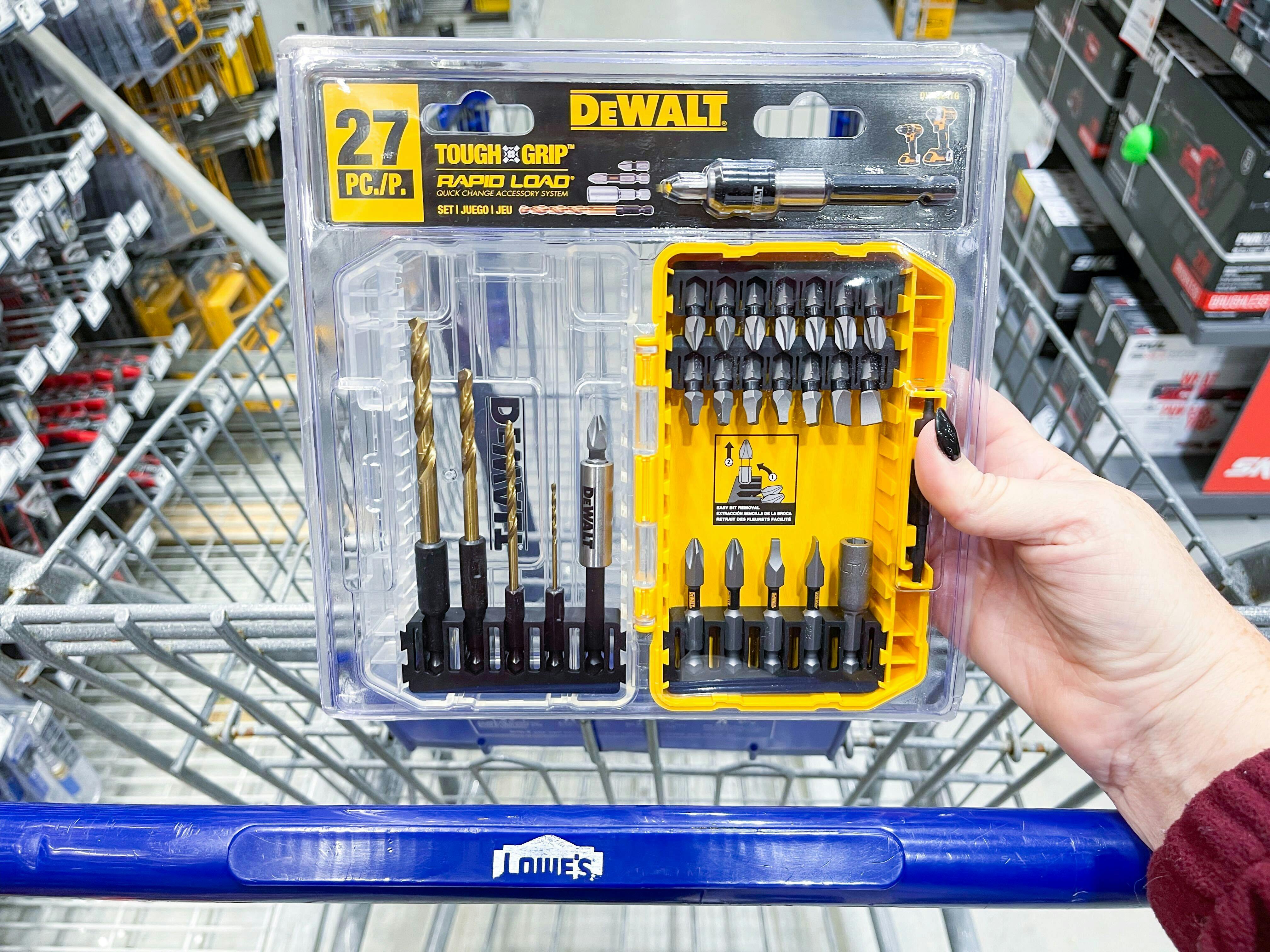 a woman's hand holding a dewalt drill bit set in front of a lowe's cart on black friday
