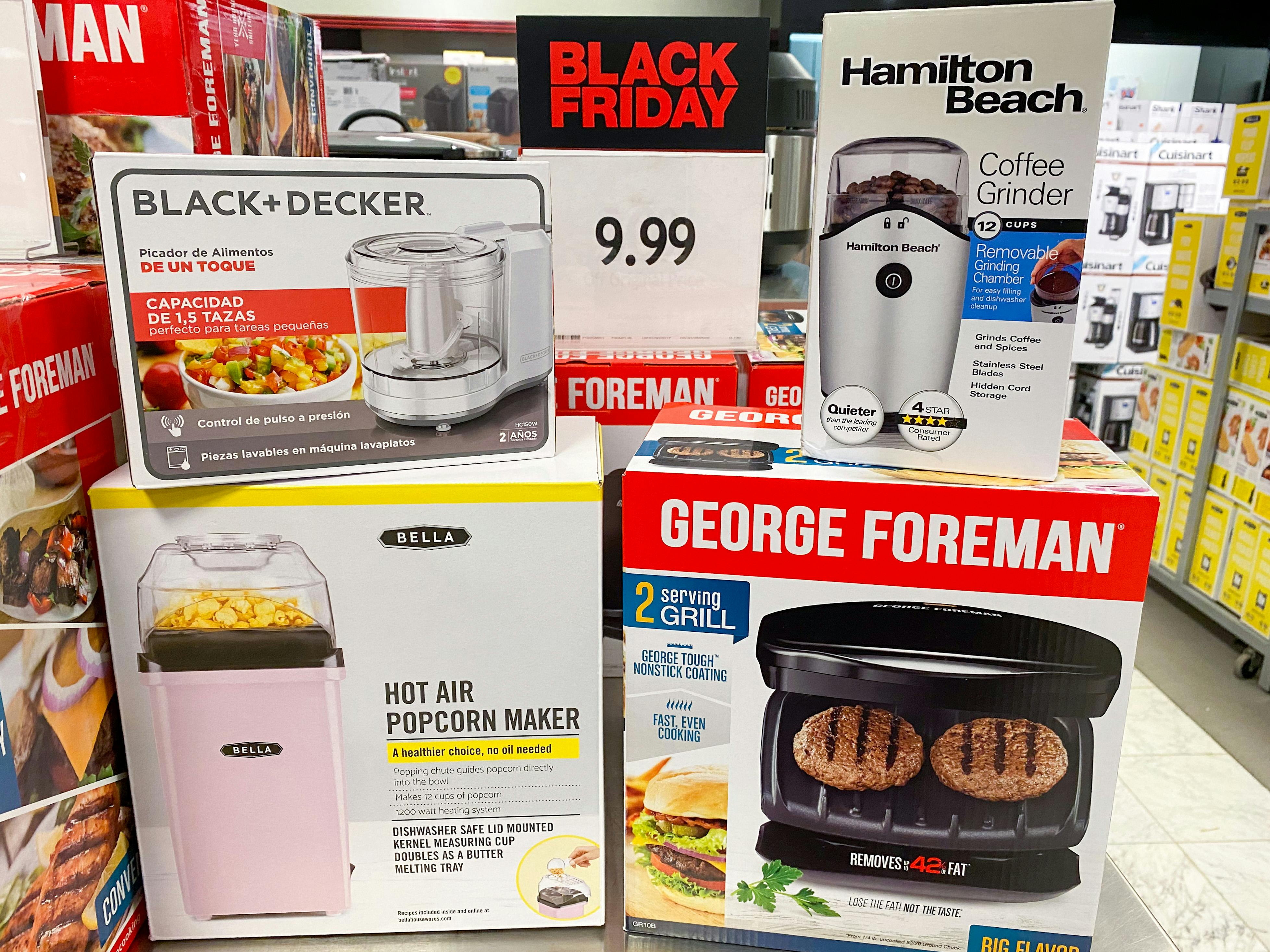 Small appliances from Black+Decker, Hamilton Beach, Bella, and George Foreman sitting on a Black Friday sale display inside Macy's.