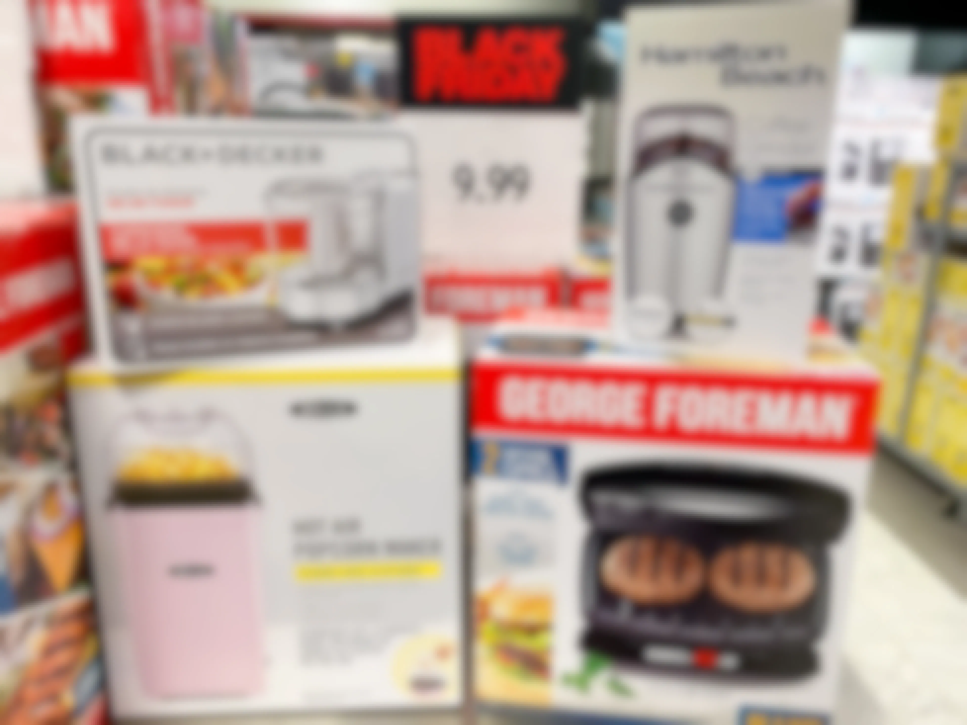 Small appliances from Black+Decker, Hamilton Beach, Bella, and George Foreman sitting on a Black Friday sale display inside Macy's.