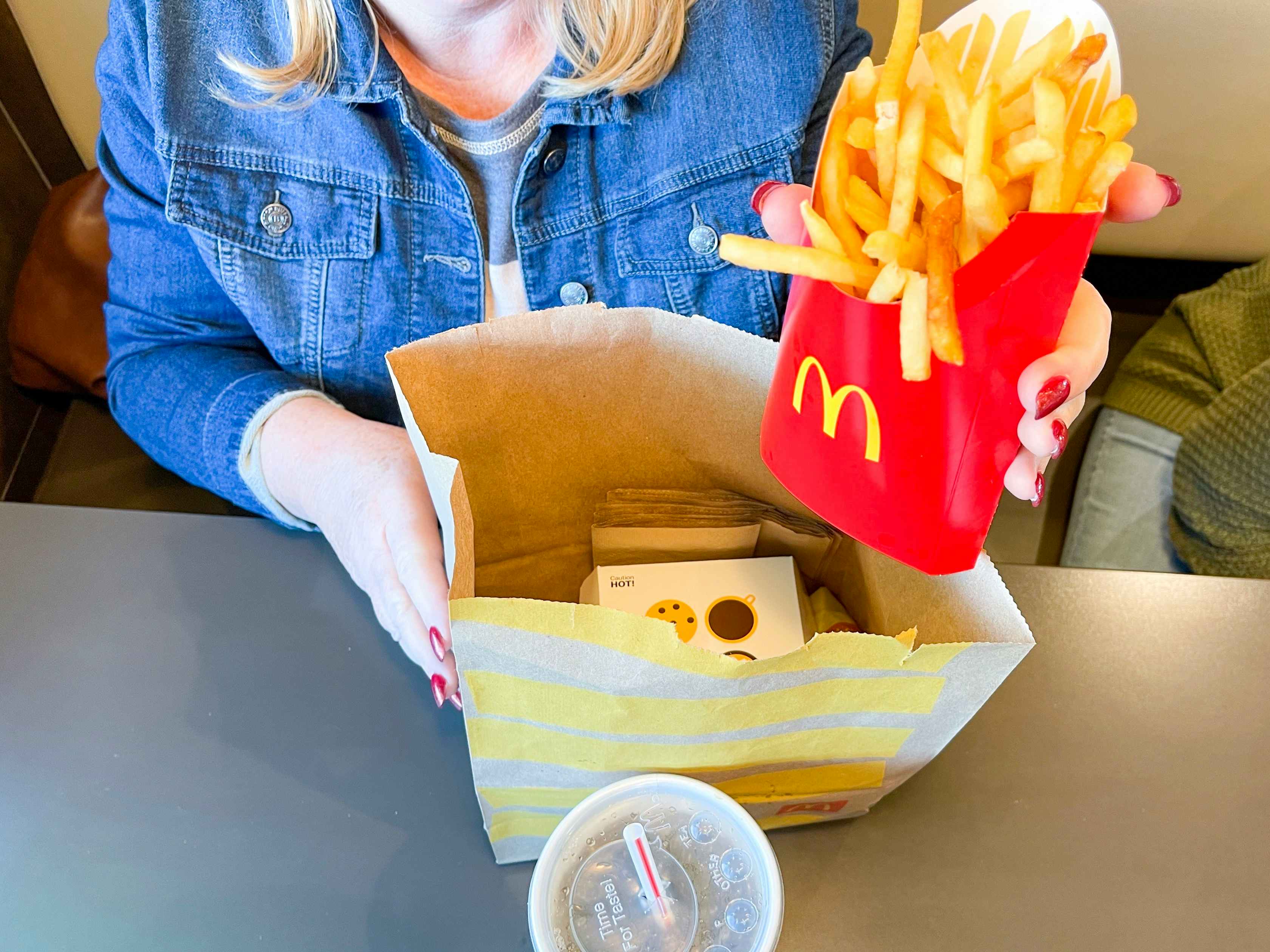 woman pulling fries out of mcdonalds bag