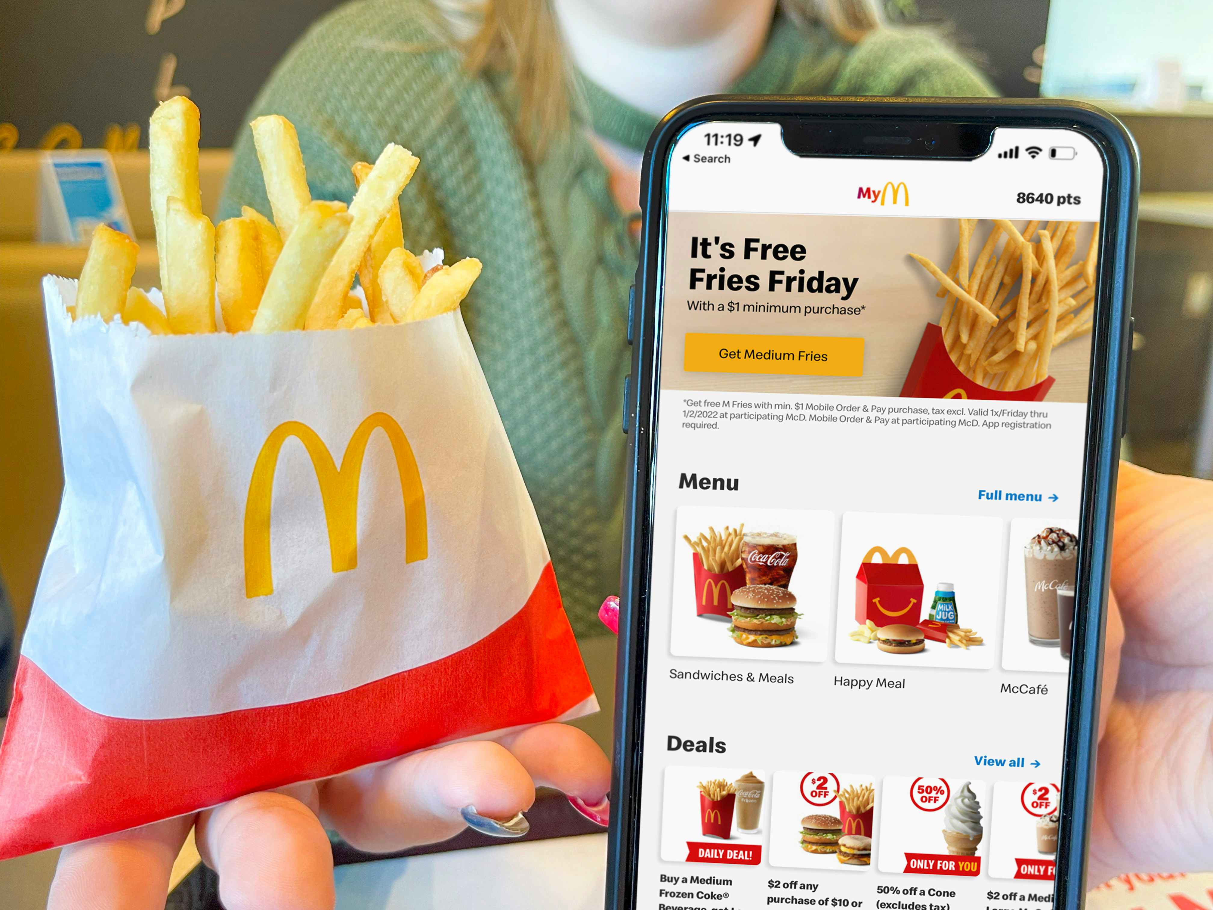 women holding cellphone with mcdonalds app and the free fast food french fries special