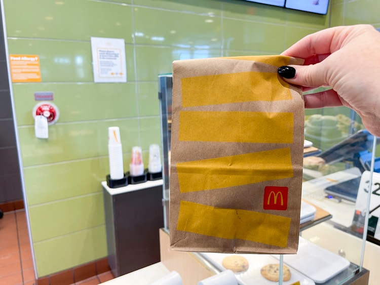 holding mcdonalds bag in restaurant