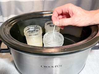 wick dropped into jars of wax