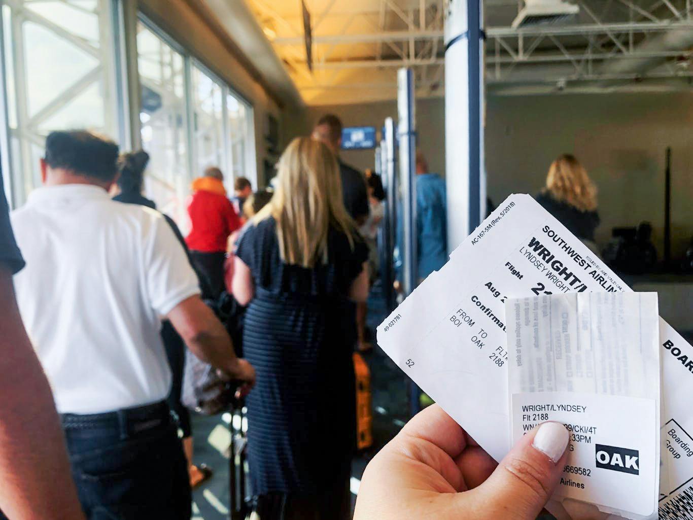 someone holding southwest tickets in boarding line at airport