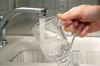 someone filling glass with water