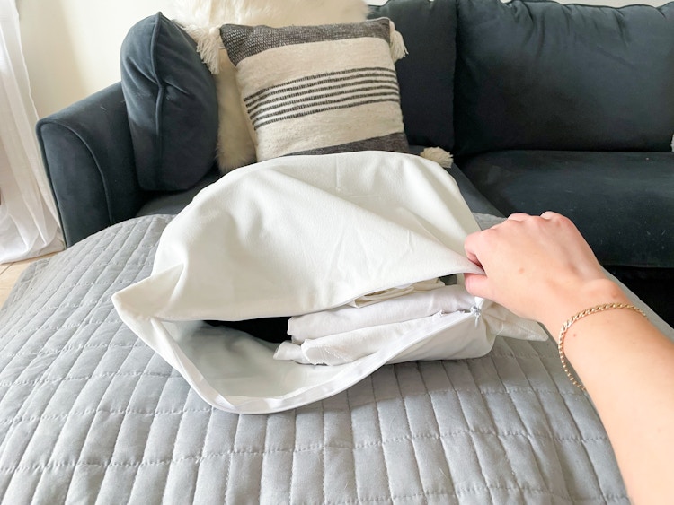 someone holding pillow with clothes in it