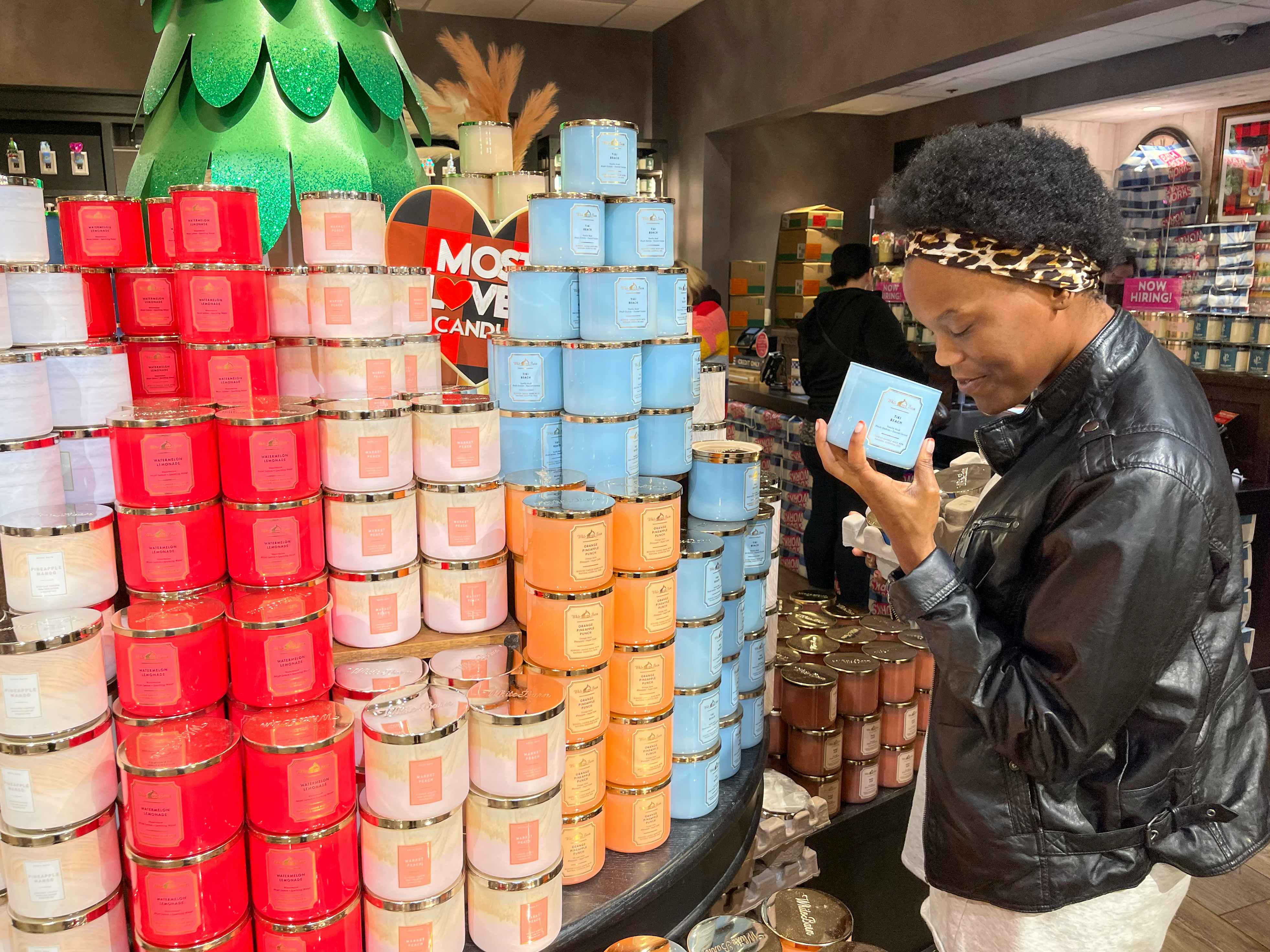 A woman smelling a candle inside bath and body works