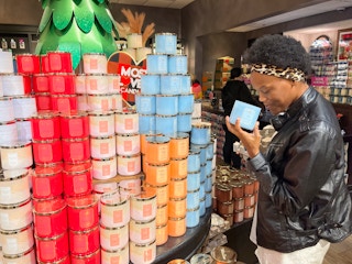 A woman smelling a candle inside bath and body works