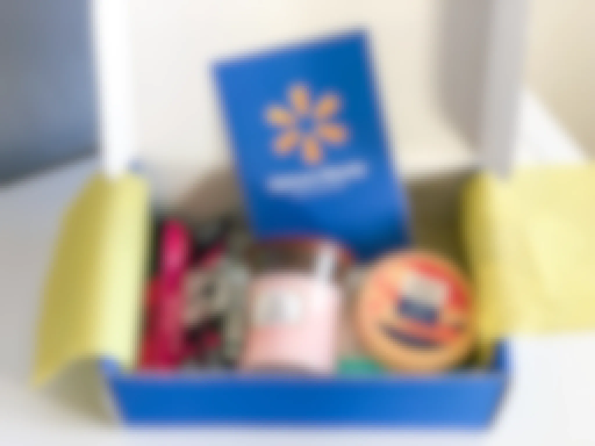A Walmart beauty box, with makeup and other beauty products, sitting open on a table.