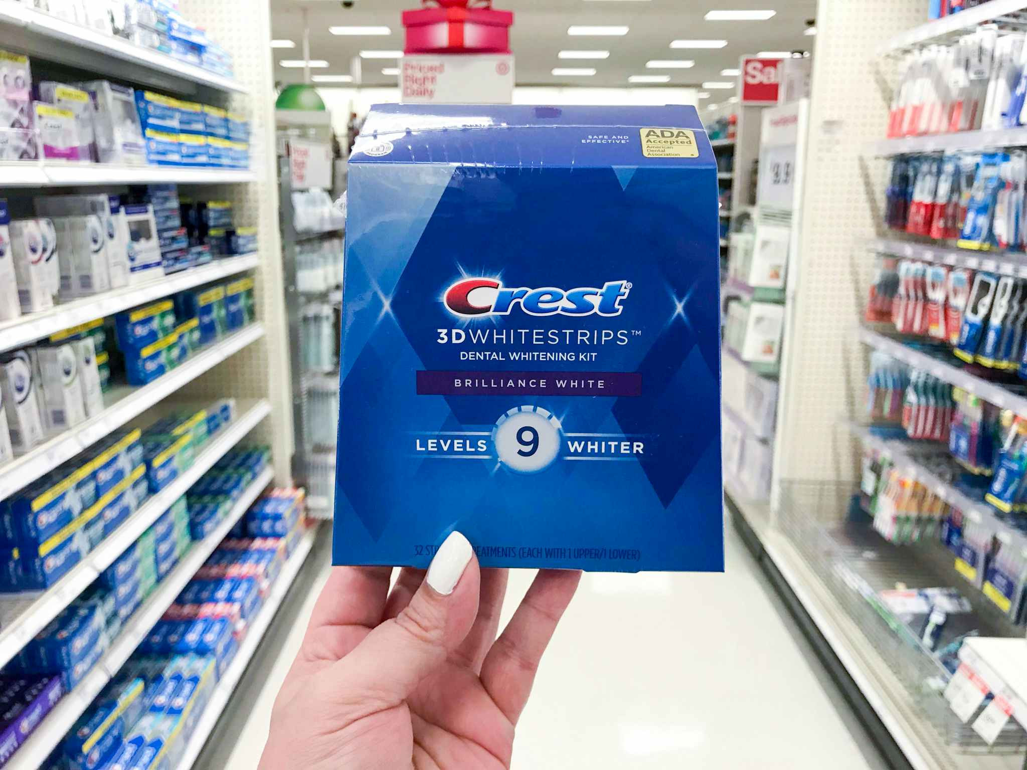 hand holding Crest White Strips box at Target in the toothrbush aisle