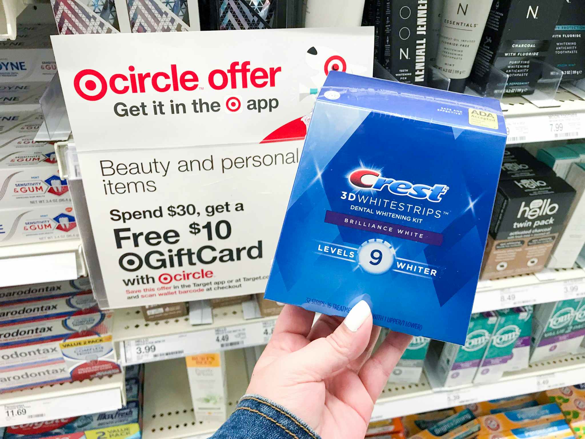 hand holding Crest White Strips box at Target in front of gift card sign