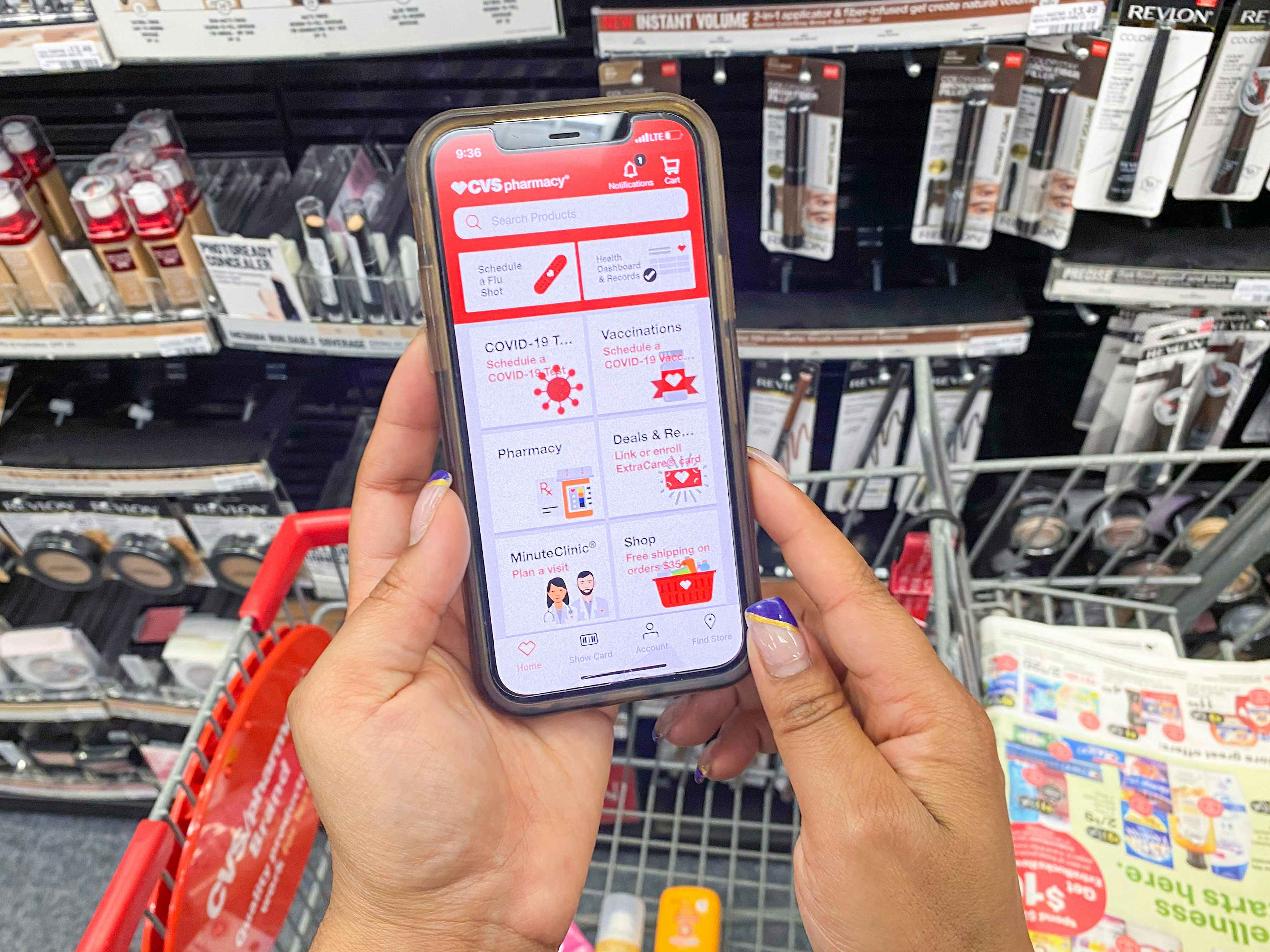 A person looking at the CVS app on their phone inside a CVS 