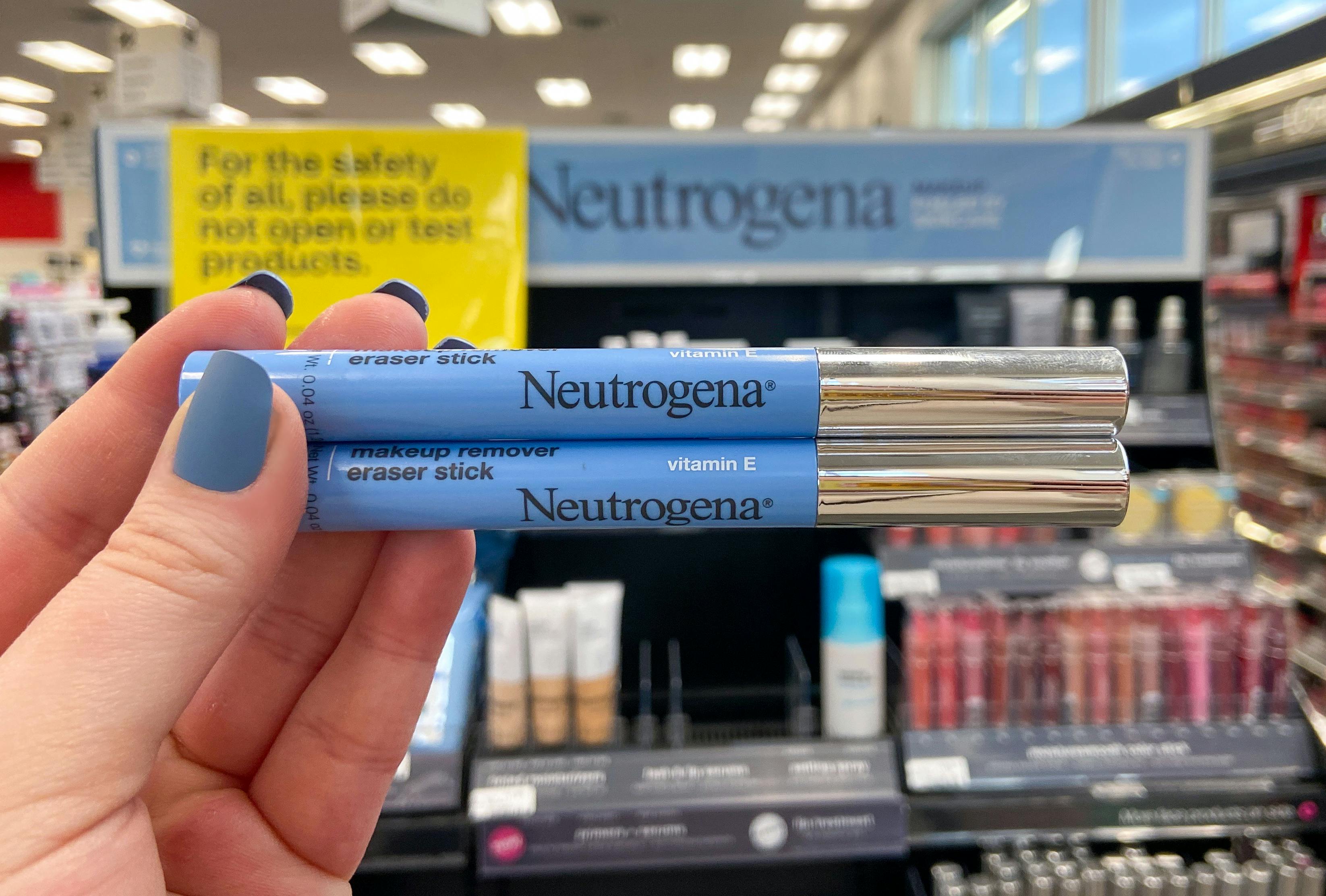 someone holding neutrogena makeup in front of neutrogena shelf at cvs