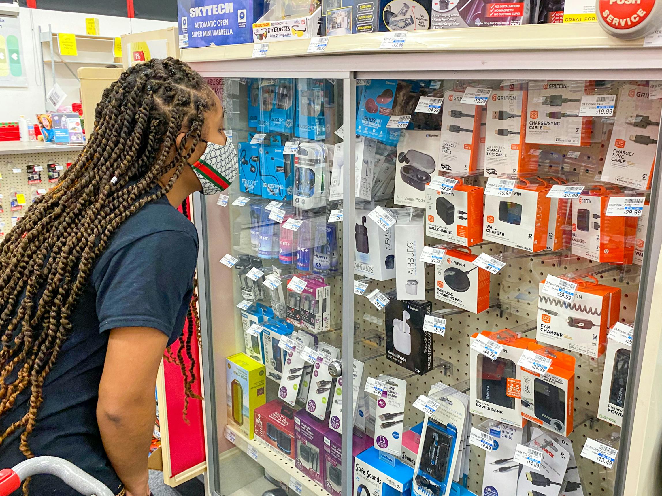 A person looking into the electronics case inside CVS.