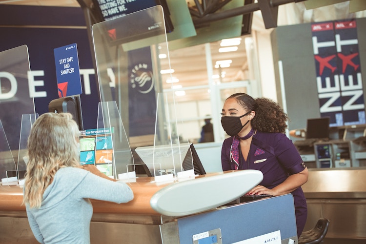 women speaking to each other at Delta desk