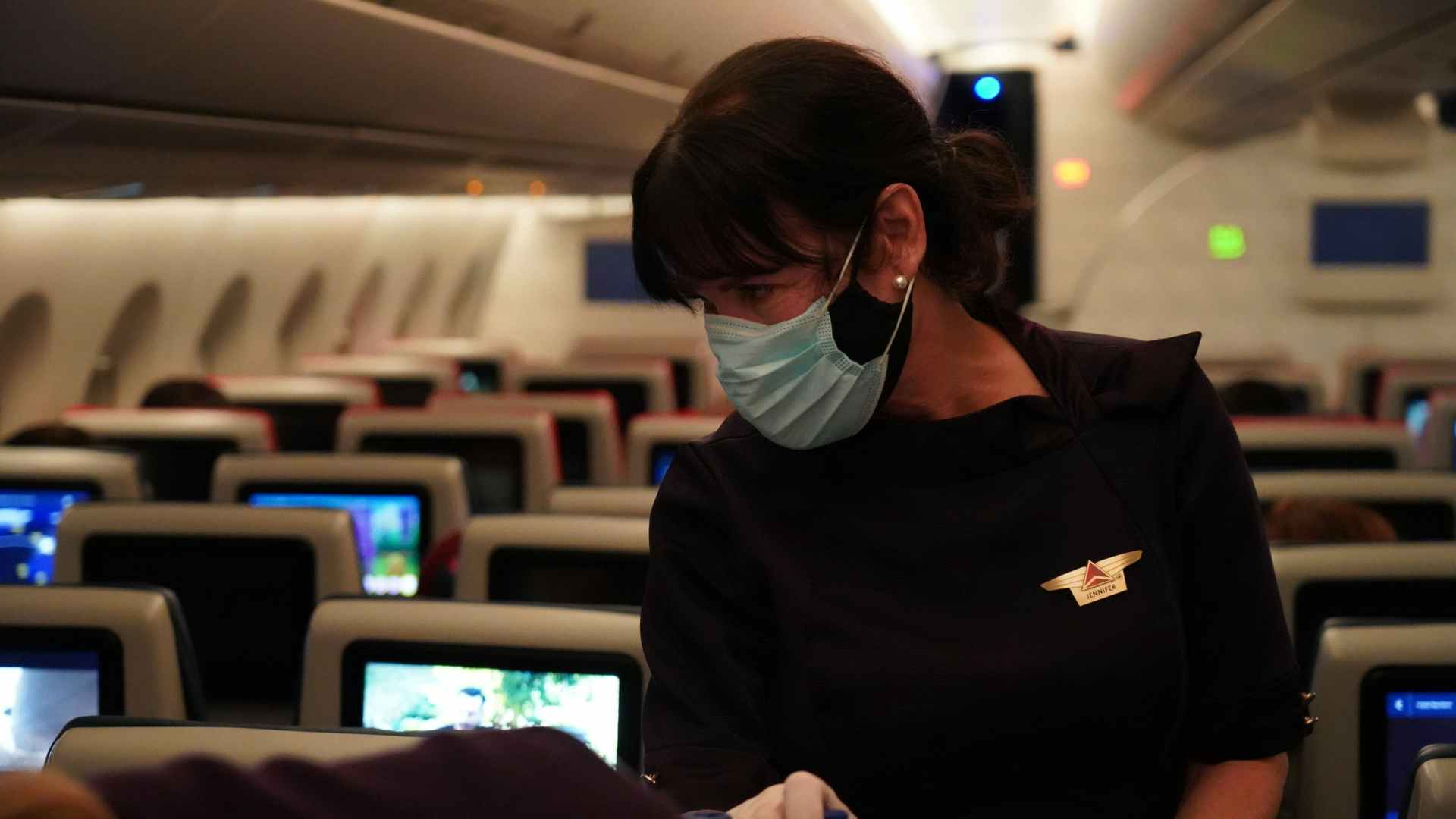 woman standing in plane aisle