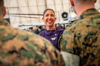 someone standing next to two people in uniform