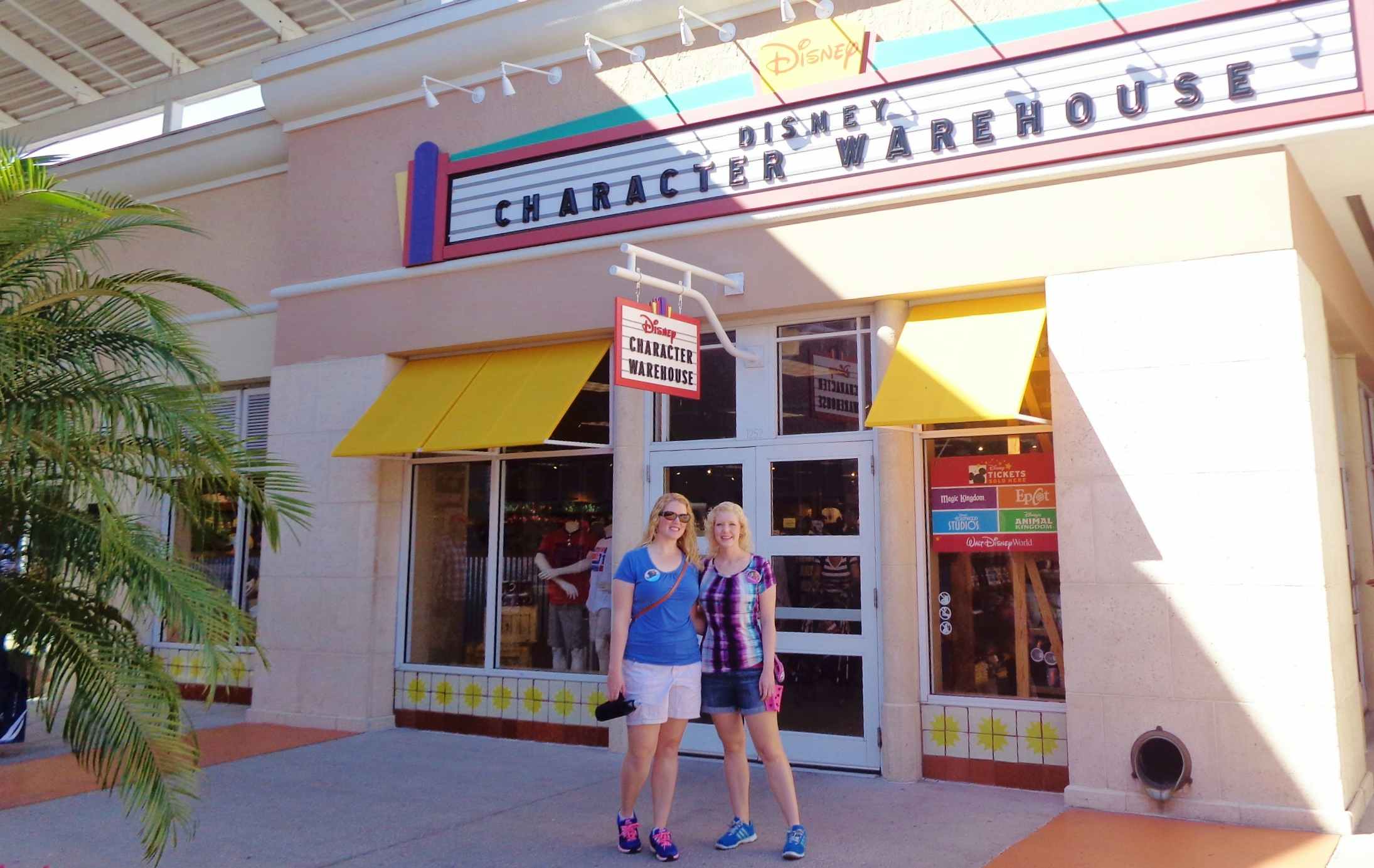 two women standing in front of disney character warehouse