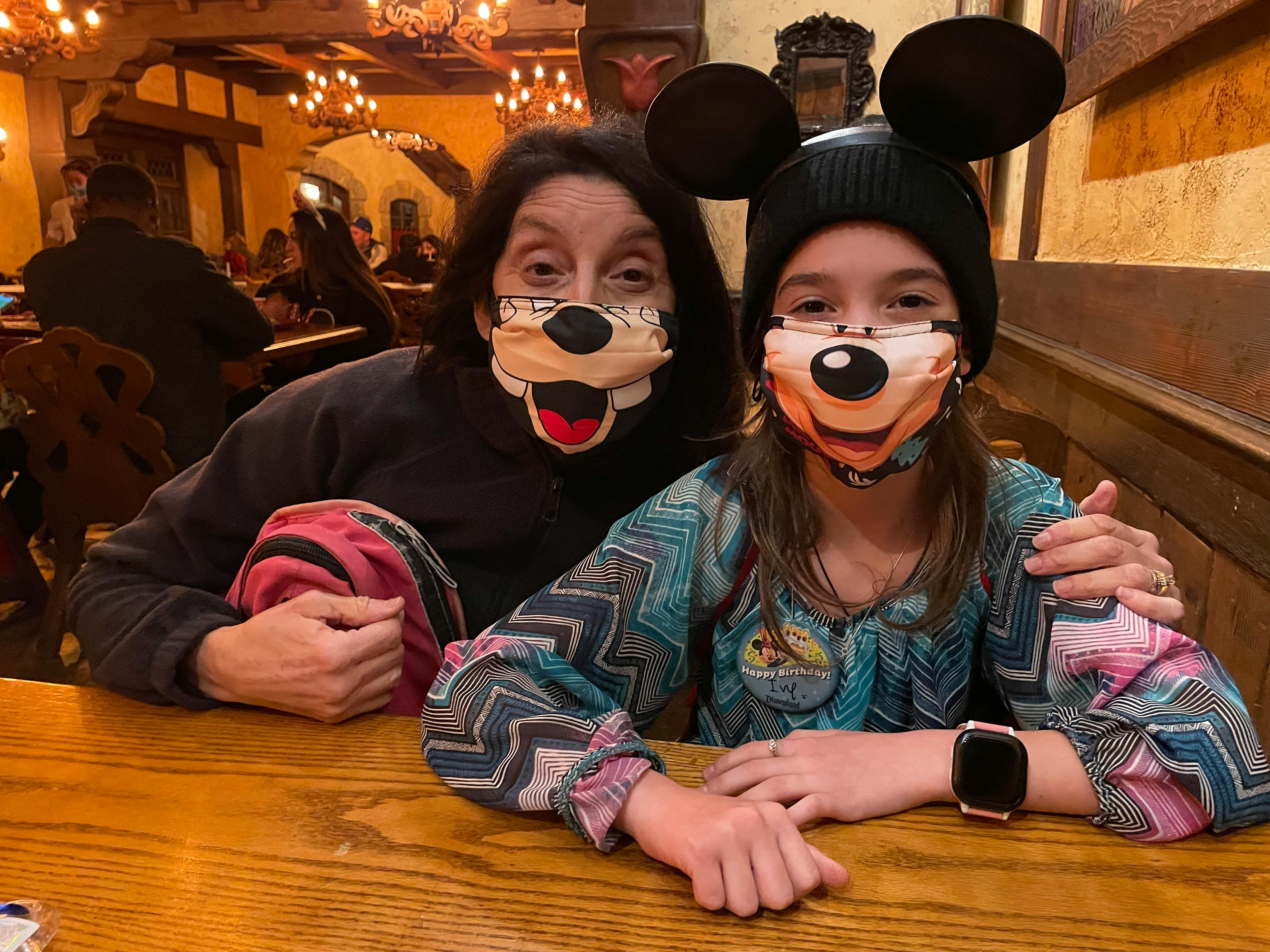 A mom and her child sitting at a booth in a Disneyland restaurant.