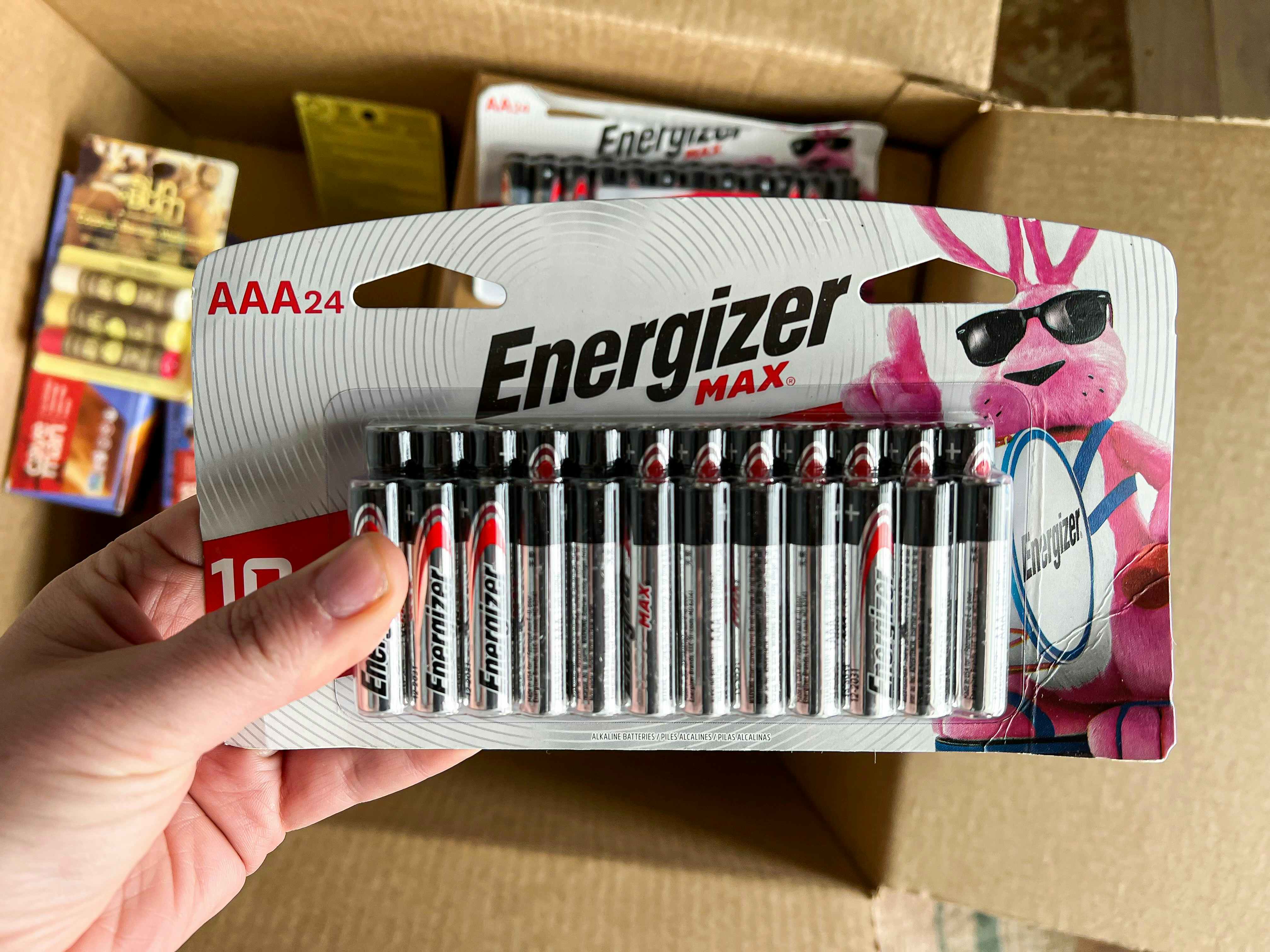 person holding energizer max AAA 24-count batteries near box