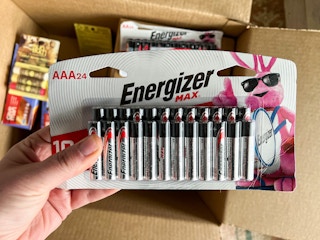 person holding energizer max AAA 24-count batteries near box
