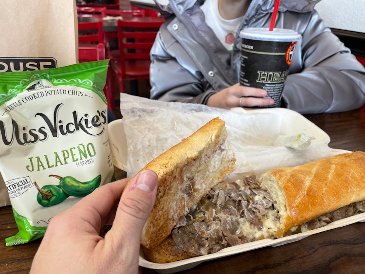 someone pulling the bread off sub sandwich at firehouse subs