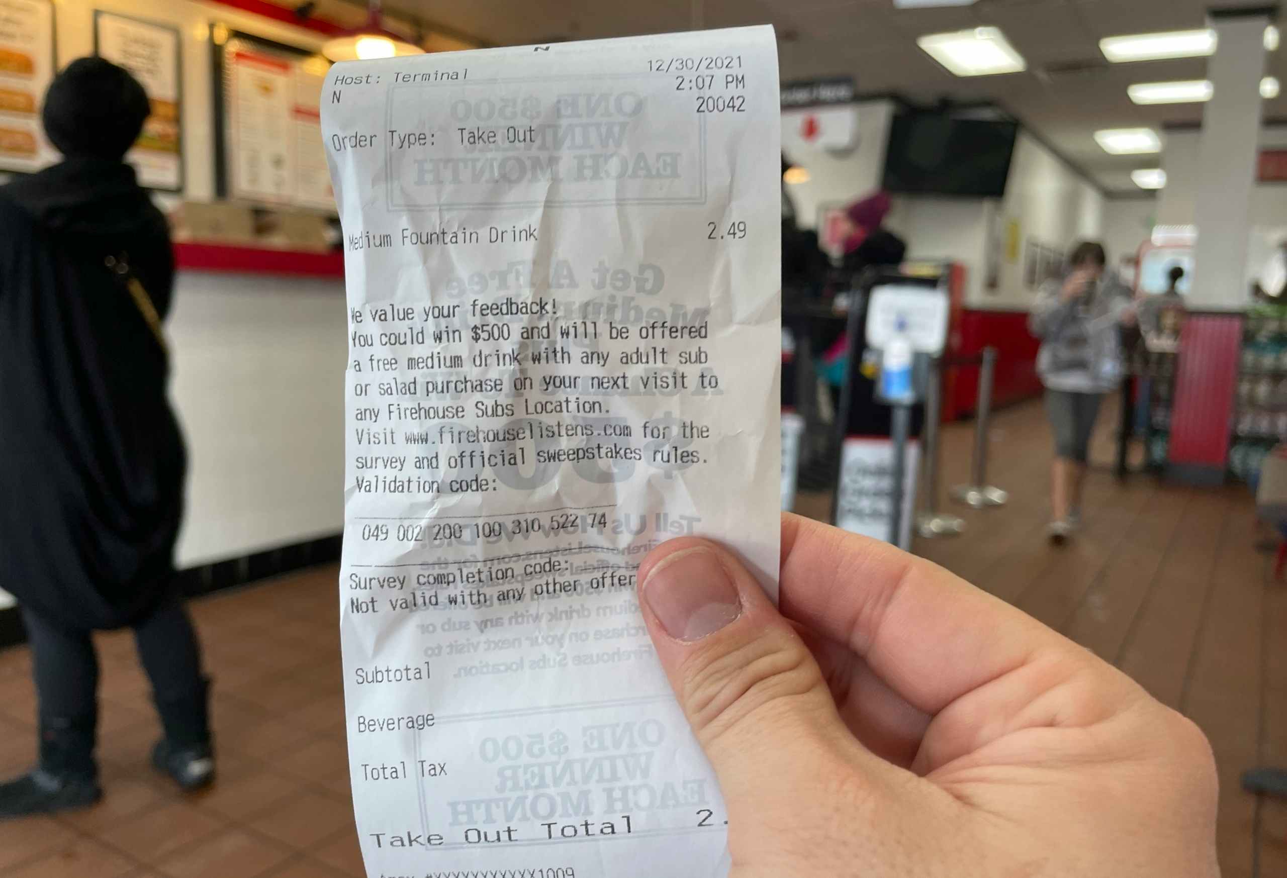 someone holding firehouse subs receipt