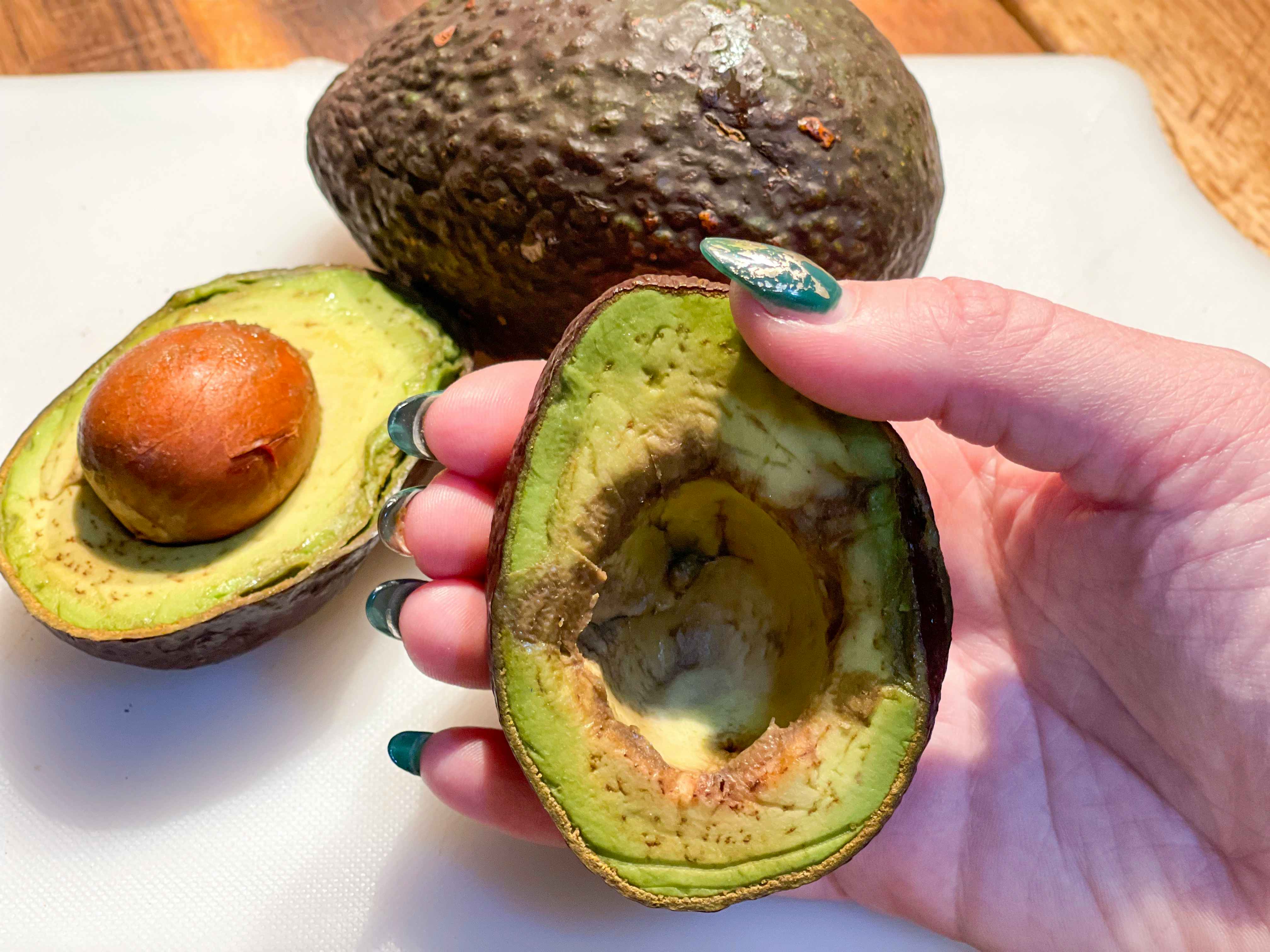 hand holding overripe avocado